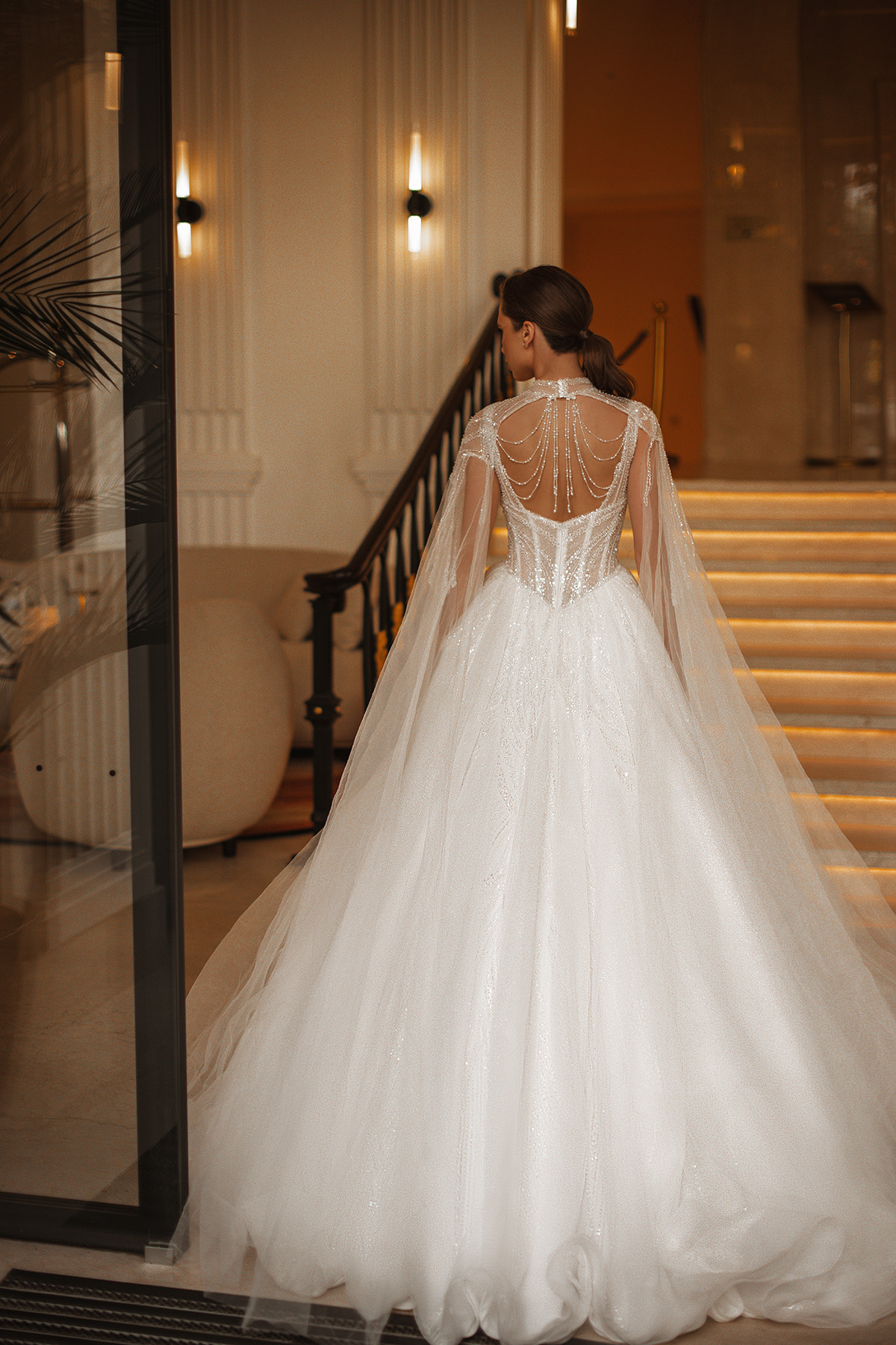 Novia de espalda con capa de tul y detalle de perlas — Blossom Caracas