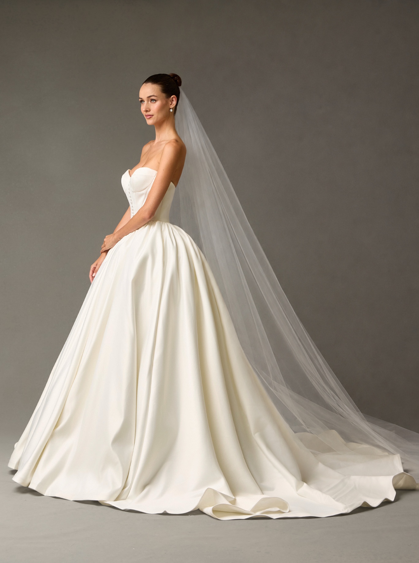 Novia de perfil con velo largo de catedral — Blossom Caracas